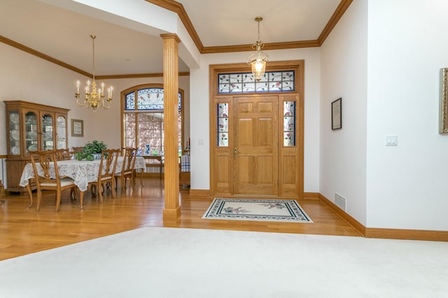 entryway with ornamental molding, a notable chandelier, visible vents, and wood finished floors