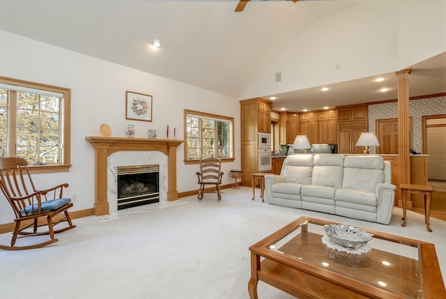 living room featuring baseboards, lofted ceiling, a fireplace, and plenty of natural light