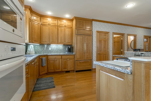 kitchen featuring light wood-style flooring, white appliances, backsplash, and recessed lighting