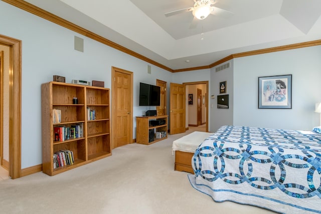 carpeted bedroom featuring a tray ceiling, crown molding, visible vents, and ceiling fan