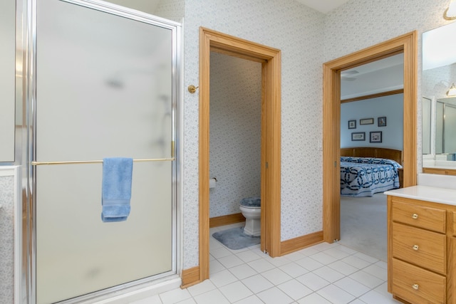 full bath with a stall shower, wallpapered walls, toilet, ensuite bathroom, and vanity