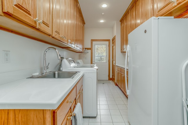 laundry area with light tile patterned floors, a sink, cabinet space, independent washer and dryer, and recessed lighting