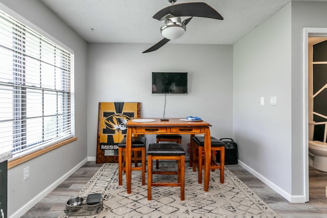 office with ceiling fan, baseboards, wood finished floors, and a textured ceiling