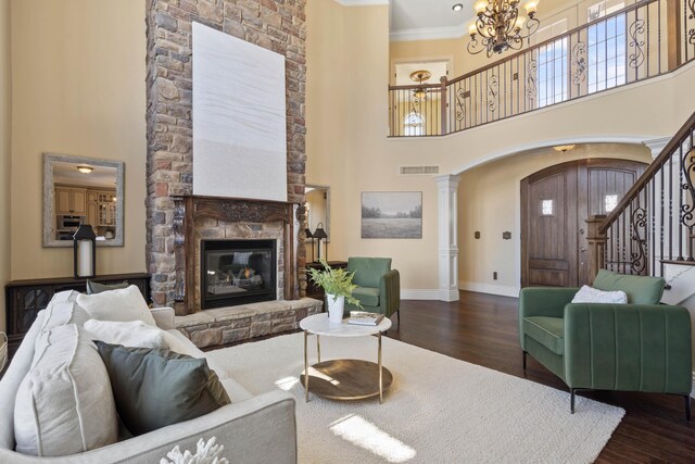 3207 Rivington Dr, Columbia, MO 65203 - living area featuring arched walkways, ornate columns, dark wood-type flooring, a chandelier, and a towering ceiling