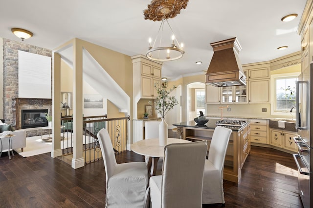 3207 Rivington Dr, Columbia, MO 65203 - dining area featuring a chandelier, dark wood-style floors, arched walkways, and a fireplace