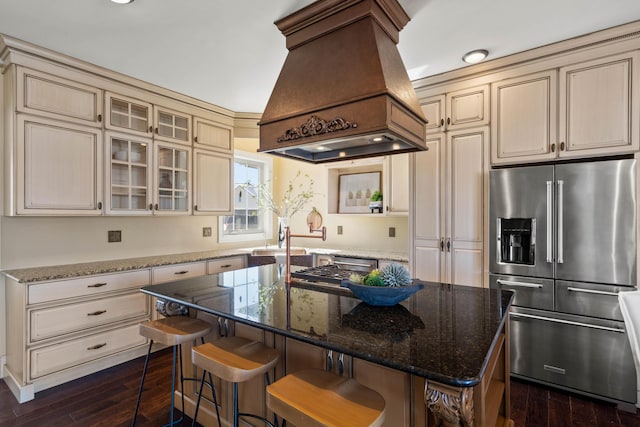 3207 Rivington Dr, Columbia, MO 65203 - kitchen with stainless steel appliances, premium range hood, cream cabinets, dark wood-style flooring, and stone countertops
