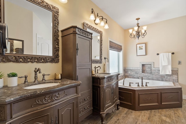 3207 Rivington Dr, Columbia, MO 65203 - bathroom featuring a chandelier, wood finished floors, a garden tub, and two vanities