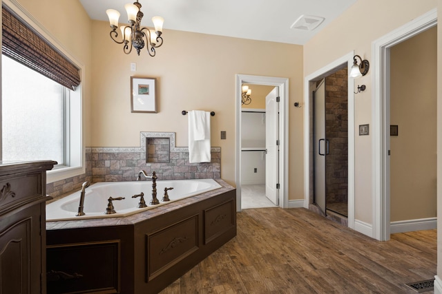 3207 Rivington Dr, Columbia, MO 65203 - full bath featuring a garden tub, a shower stall, a chandelier, and wood finished floors