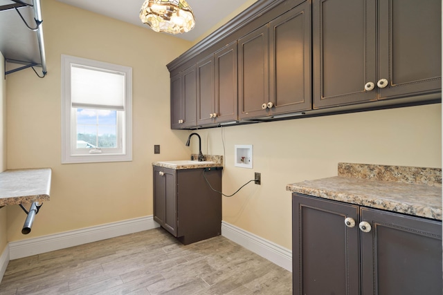 3207 Rivington Dr, Columbia, MO 65203 - washroom with cabinet space, washer hookup, baseboards, and light wood-style flooring