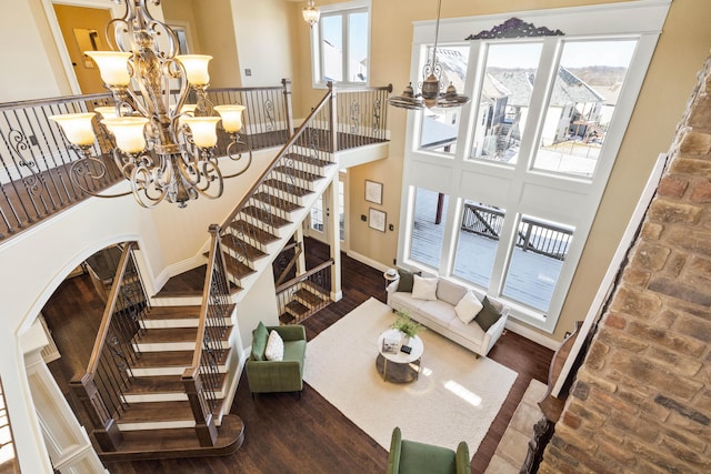 3207 Rivington Dr, Columbia, MO 65203 - staircase with a chandelier, a towering ceiling, arched walkways, and wood finished floors
