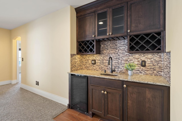 3207 Rivington Dr, Columbia, MO 65203 - indoor wet bar featuring arched walkways, decorative backsplash, baseboards, and carpet