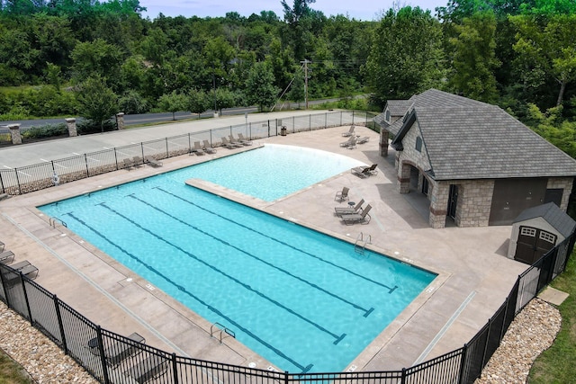 3207 Rivington Dr, Columbia, MO 65203 - community pool featuring fence, a patio area, an outdoor structure, and a wooded view