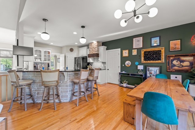 5109 Newbury Way, Columbia, MO 65203 - kitchen with stainless steel fridge with ice dispenser, light wood-style flooring, a peninsula, white cabinetry, and decorative backsplash