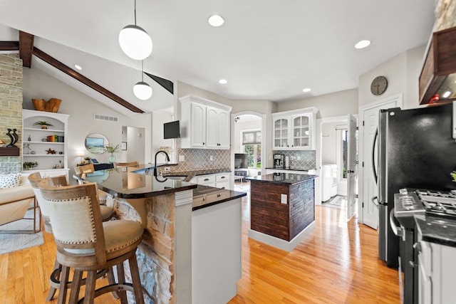 5109 Newbury Way, Columbia, MO 65203 - kitchen with visible vents, a sink, light wood-type flooring, backsplash, and washing machine and dryer