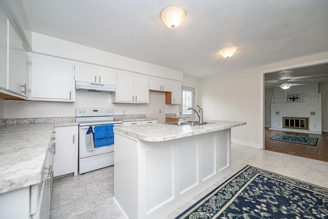 kitchen featuring under cabinet range hood, light countertops, a sink, electric range, and white cabinetry