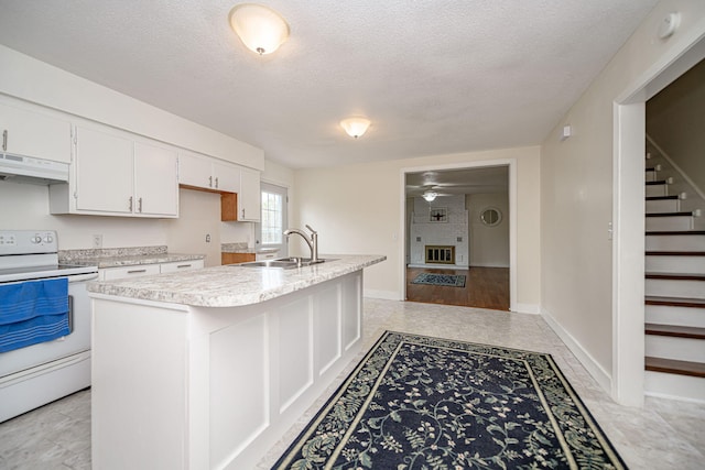 kitchen featuring a sink, white cabinetry, light countertops, under cabinet range hood, and white range with electric cooktop