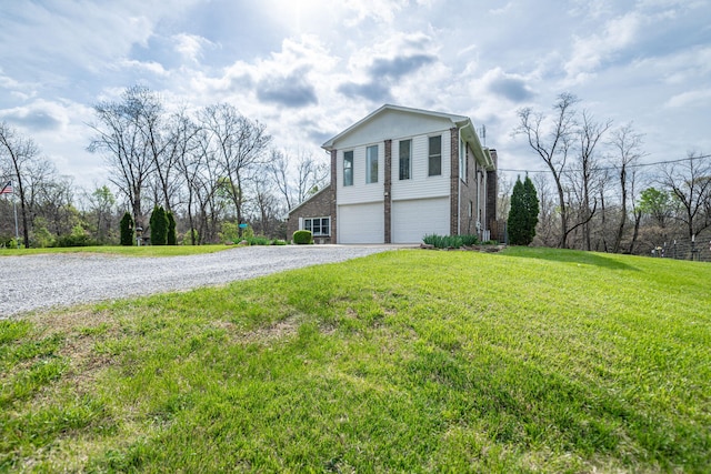 view of side of property with a lawn, gravel driveway, and a garage