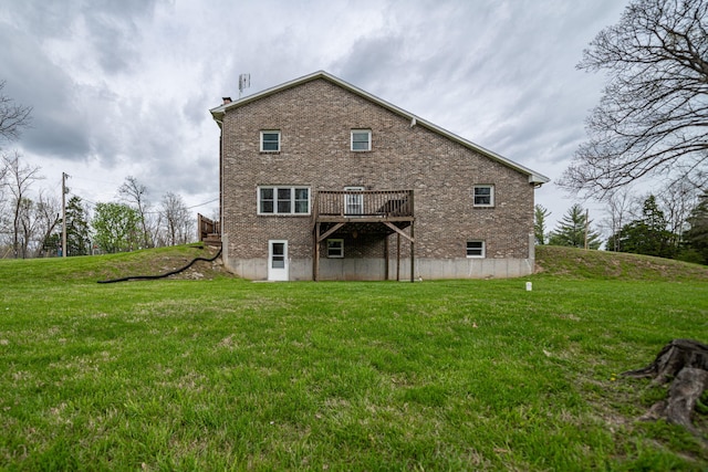 back of property featuring a lawn, brick siding, and a wooden deck