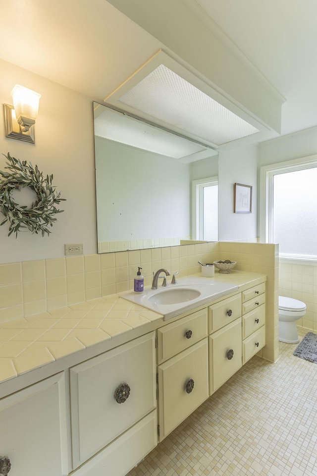 30 Holman Rd, Moberly, MO 65270 - bathroom featuring tile walls, toilet, plenty of natural light, and vanity