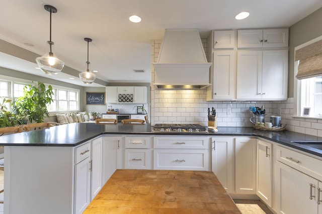 30 Holman Rd, Moberly, MO 65270 - kitchen featuring a wealth of natural light, stainless steel gas cooktop, premium range hood, and dark countertops