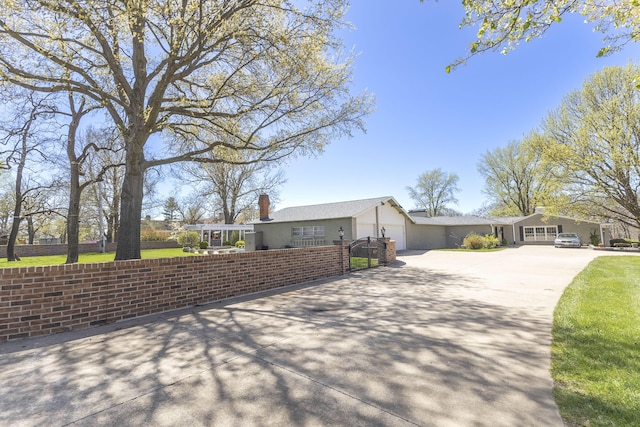 30 Holman Rd, Moberly, MO 65270 - ranch-style house featuring a chimney, an attached garage, driveway, and a fenced front yard