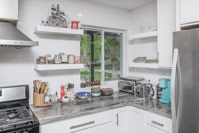 kitchen with open shelves, appliances with stainless steel finishes, decorative backsplash, white cabinets, and wall chimney range hood