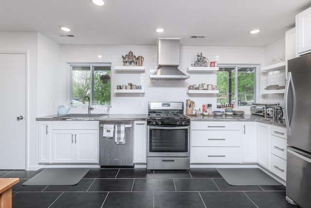 kitchen with stainless steel appliances, wall chimney exhaust hood, open shelves, a sink, and recessed lighting