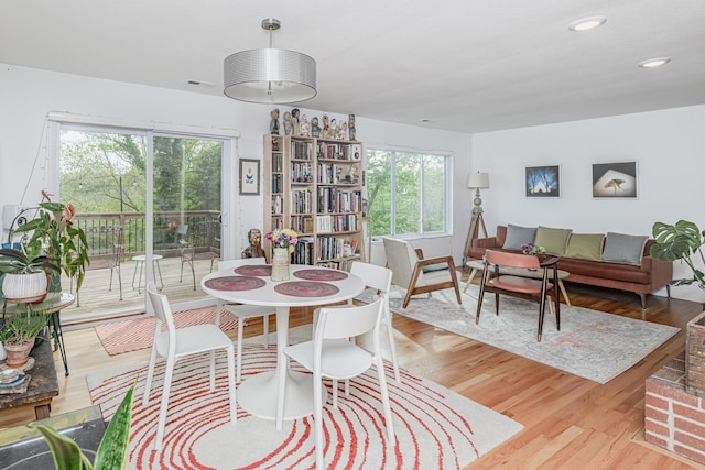 dining area featuring healthy amount of natural light, wood finished floors, and recessed lighting