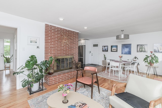 living area with light wood-style floors, a fireplace, and recessed lighting