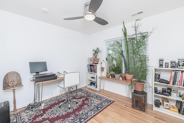 office space featuring wood finished floors, ceiling fan, and baseboards