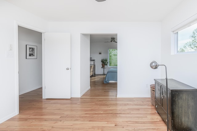 hall featuring light wood-style floors and baseboards