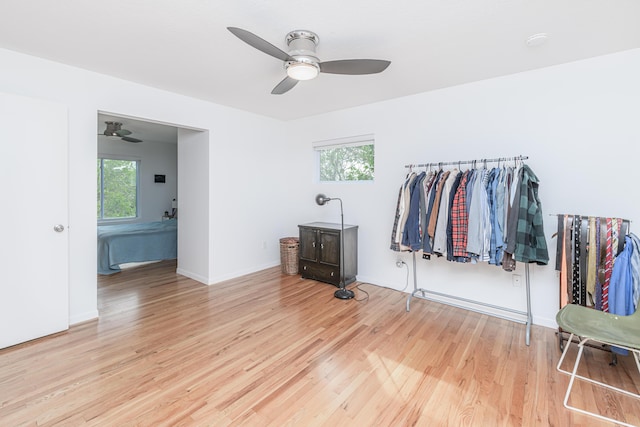 bedroom with multiple windows, light wood finished floors, baseboards, and ceiling fan