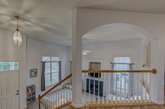 entryway featuring baseboards, a ceiling fan, arched walkways, and a healthy amount of sunlight