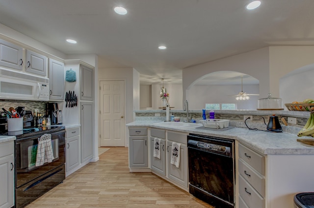 kitchen featuring ceiling fan, light countertops, a sink, backsplash, and black appliances