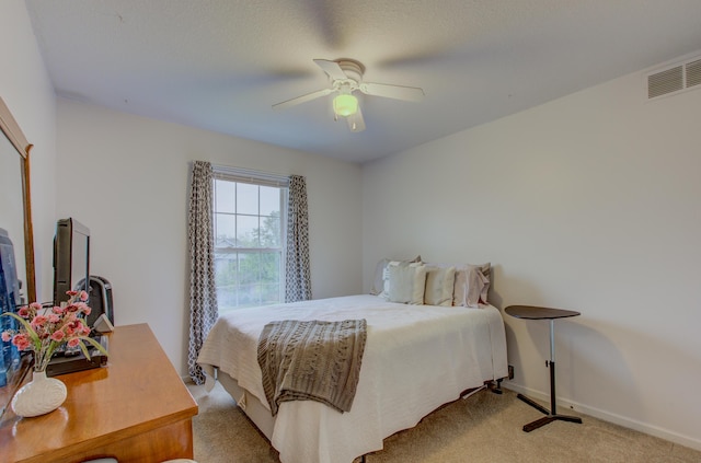 bedroom featuring a ceiling fan, baseboards, light colored carpet, and visible vents