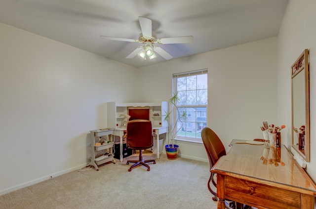 carpeted office space with baseboards and ceiling fan