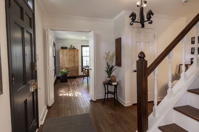 foyer entrance featuring dark wood-style floors, stairway, a chandelier, ornamental molding, and baseboards