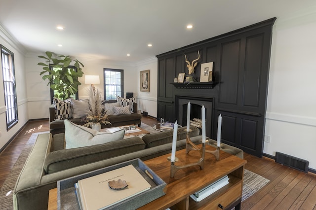 living area with crown molding, a large fireplace, dark wood-style floors, recessed lighting, and baseboards
