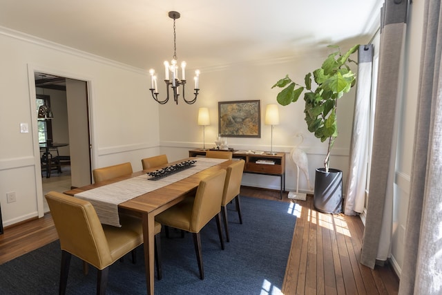 dining space with a chandelier, dark wood finished floors, ornamental molding, and baseboards