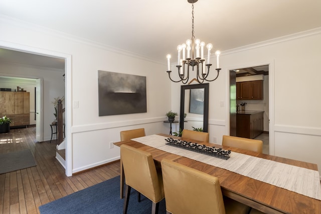 dining space featuring a chandelier, crown molding, hardwood / wood-style floors, and baseboards