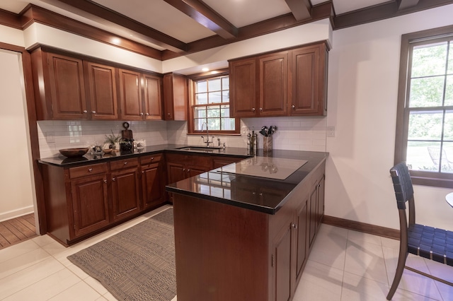 kitchen with a sink, dark countertops, a peninsula, decorative backsplash, and beamed ceiling