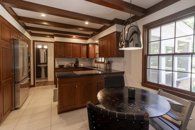 kitchen featuring a sink, high end fridge, beam ceiling, a peninsula, and decorative backsplash