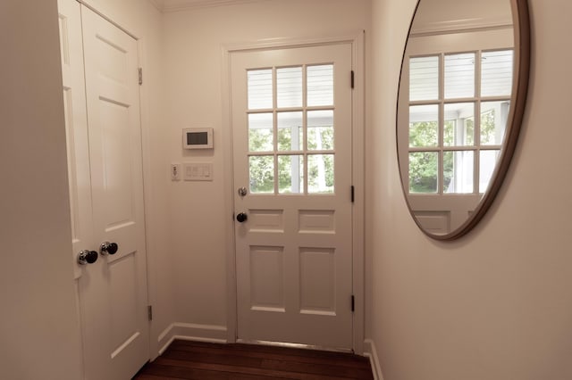 entryway with dark wood finished floors, baseboards, and crown molding