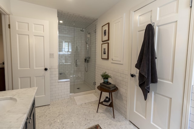 full bathroom featuring a stall shower, vanity, tile patterned floors, and tile walls