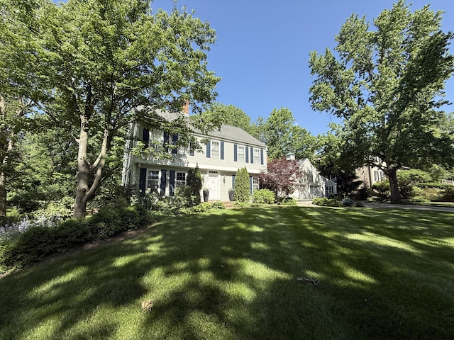 back of house with a lawn and a chimney