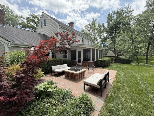 back of property featuring an outdoor fire pit, a lawn, a sunroom, a patio area, and a chimney