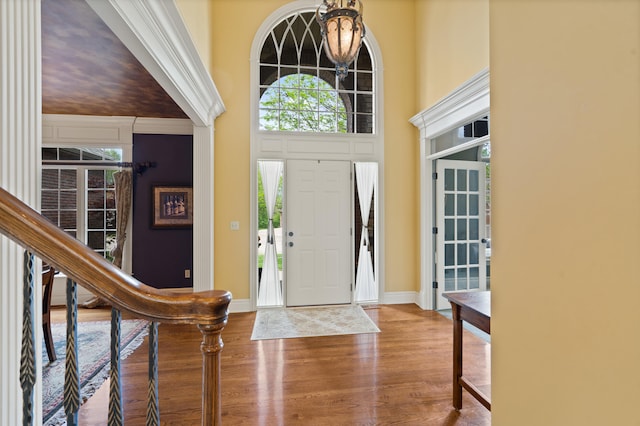 entrance foyer featuring stairway, wood finished floors, a healthy amount of sunlight, and baseboards