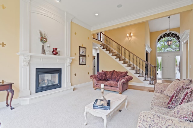 living area with stairway, a fireplace, baseboards, ornamental molding, and carpet flooring