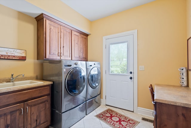 clothes washing area with visible vents, light tile patterned floors, a sink, washer and dryer, and cabinet space
