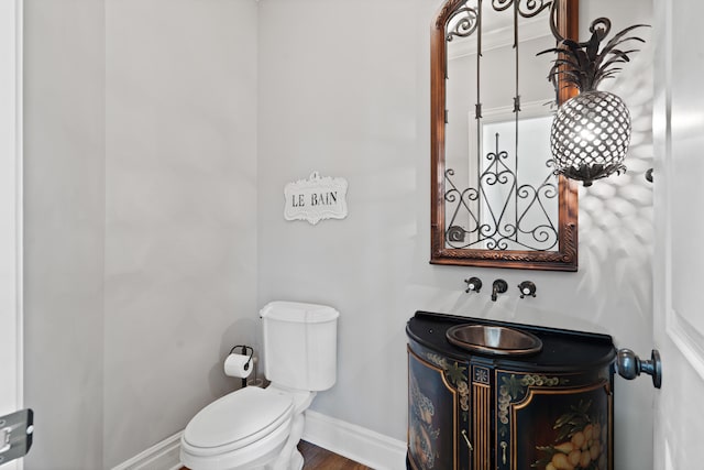 bathroom with vanity, toilet, and baseboards